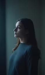 a woman standing in front of a window with her hands folded back
