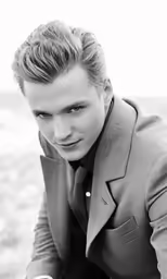 black and white photograph of young man in business suit looking at camera