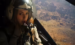 a woman in a helicopter with a camera and helmet