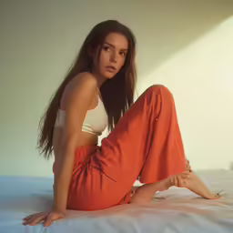 a beautiful woman posing on a white bed
