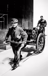 a man in suit walking past a horse drawn carriage