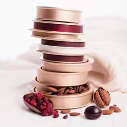 there are nuts and a piece of fruit around the containers