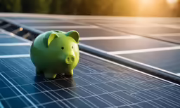 a green piggy bank sitting on a solar powered field