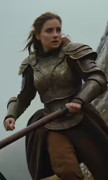 a woman with a sword is standing on some rocks