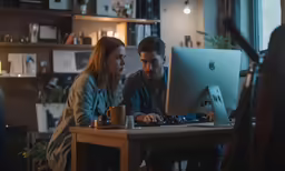 a man and woman are working on a computer