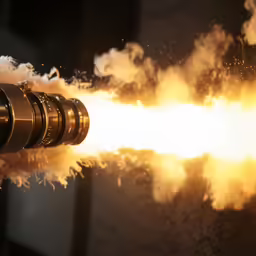 a very big shiny pipe going by with some very bright lights