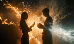 two people in the dark with fireworks in the background
