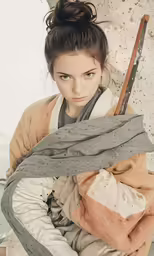a woman with two swords on her arm and a blanket around her neck