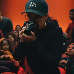 there is a man taking a picture in a crowd
