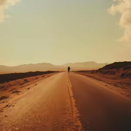 a lone man is standing alone on the empty road