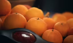 a basket of oranges, a spoon and saucer