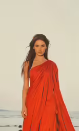 a woman in an orange dress and red cape