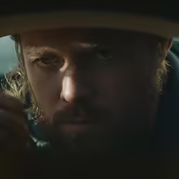 the man in a hat is looking around his corner
