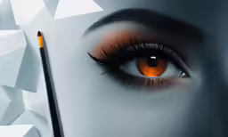 an eyeliner brush in front of an orange eye