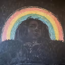 a man standing underneath an umbrella with a rainbow over it