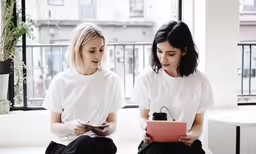 two young ladies looking at a tablet device