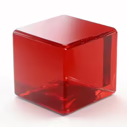 a small square glass object with red paint
