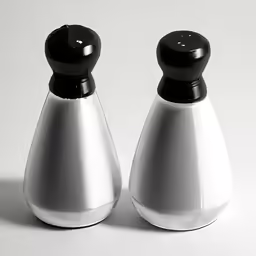 two white salt and pepper shakers with black knobs