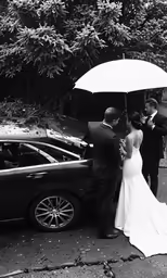 the bride and groom are standing under an umbrella