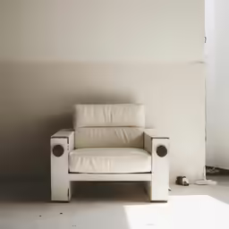 a white leather chair sitting in an empty room