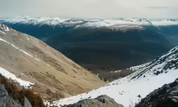 a snow covered landscape with mountains and clouds