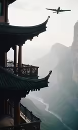 an airplane flying low over a building near mountains