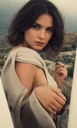 a beautiful woman posing for the camera on top of a mountain