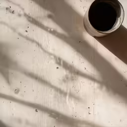 shadows cast on the wall behind the cup