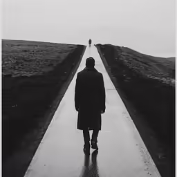 a man standing on a wet concrete path
