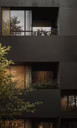 a tall black building with plants growing out the windows