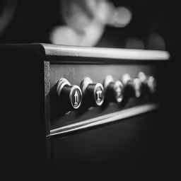 close up of the knobs on an old black piano
