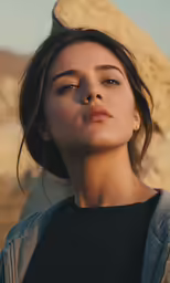 woman standing in front of a rock face and her eyes closed