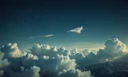 a cloud with mountains in the background in a sunny sky