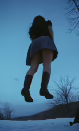 a woman with boots walking on snow covered ground