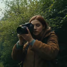 a woman holding a camera and taking a photo