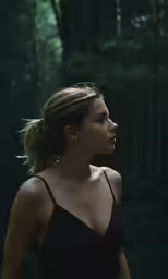 a woman in a dark top in the woods