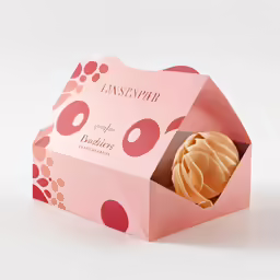 a pink box with a pastry inside