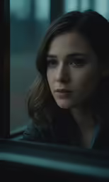 a woman staring out a window at someone