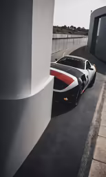 an black car is parked near a tall building