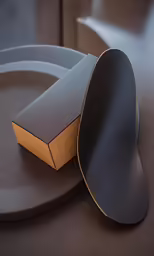an orange and black object sits on a dark table