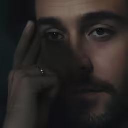 the man is posing for the camera with his hand on his face