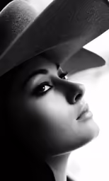 a black and white photograph of a woman with a cowboy hat