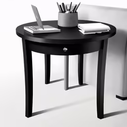 black table with laptop and pens on top