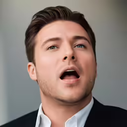 a man in a suit and tie making a surprised face