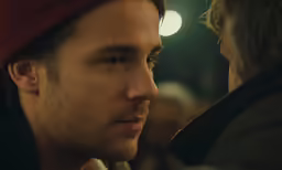 man wearing head scarf and hat while facing other people