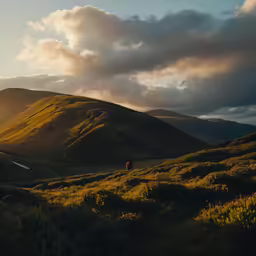 a man is walking across a mountain with the sun shining
