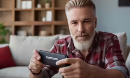 a man with long hair, beard and white hair holding a cell phone
