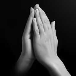two hands that are clasped together against a black background
