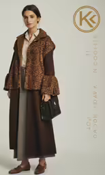 a woman in brown coat and shoes standing by white background