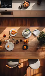 several plates are setting on a table, with oranges, tea and juice